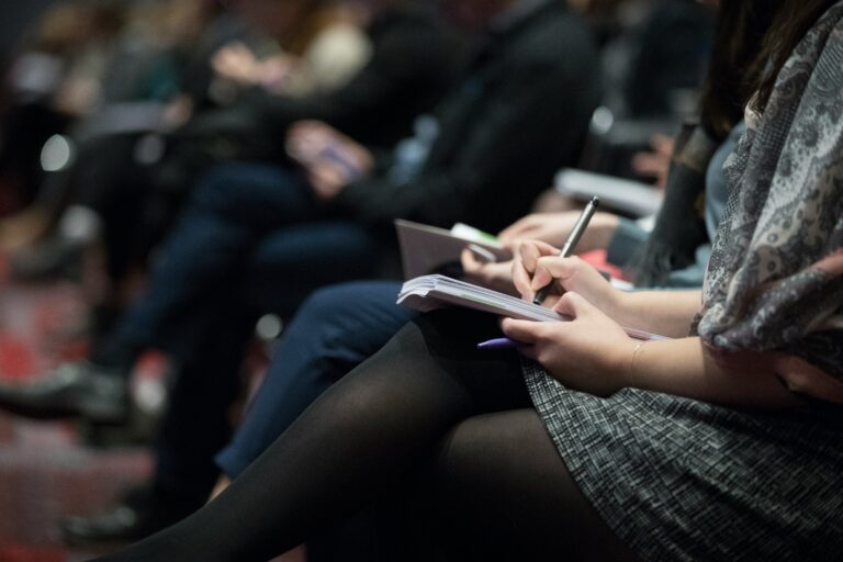 People taking notes in training seminar