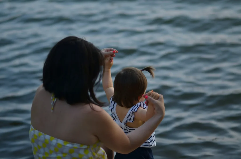 Mother and daughter beside sea or lake