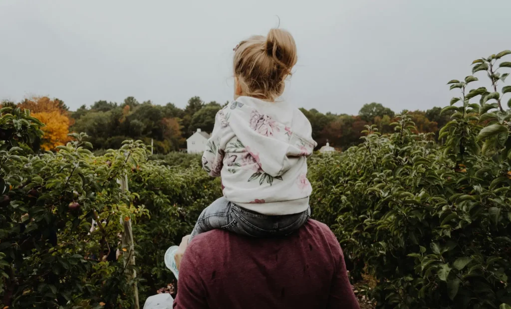 Father carrying young daughter on his shoulders